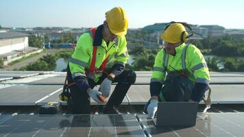 tutti e due di tecnici è installazione solare pannelli su il tetto di il magazzino per modificare solare energia in elettrico energia per uso nel fabbriche. foto