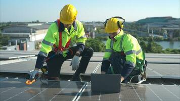 tutti e due di tecnici è installazione solare pannelli su il tetto di il magazzino per modificare solare energia in elettrico energia per uso nel fabbriche. foto