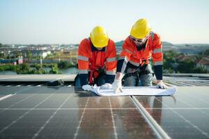 ingegnere e tecnico Lavorando su il solare pannello su il magazzino tetto per ispezionare il solare pannelli quello avere stato nel operazione per alcuni volta. foto