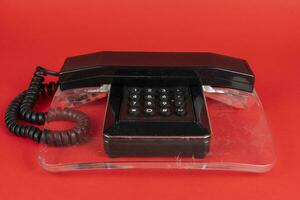 nero e trasparente Vintage ▾ telefono al di sopra di un' rosso sfondo foto