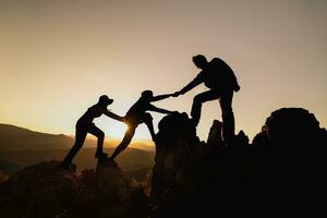 silhouette di lavoro di squadra di tre escursionista porzione ogni altro su superiore di montagna arrampicata squadra. lavoro di squadra amicizia escursioni a piedi Aiuto ogni altro fiducia assistenza silhouette nel montagne, Alba. foto