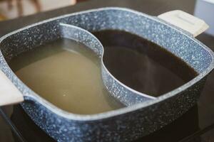 yin yang cartello suki caldo pentola shabu la minestra Due colori di la minestra nel stesso pentola. foto