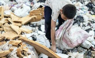 povero bambini su il spazzatura cumulo di rifiuti e Selezione plastica rifiuto per vendere, bambini non nel scuola, povertà. foto