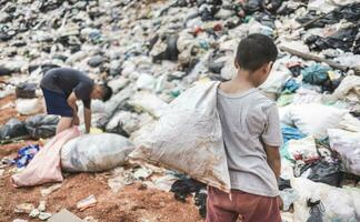 i bambini poveri raccolgono immondizia per la vendita a causa della povertà, il riciclaggio della spazzatura, il lavoro minorile, il concetto di povertà, la giornata mondiale dell'ambiente, foto