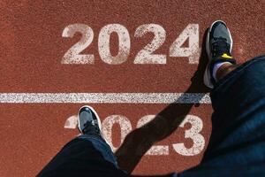 il inizio di 2024 è scritto su un' colorato strada. concettuale foto di il In arrivo nuovo anno 2024. nuovo anno concetto, motivazione, attività commerciale promozione, passo inoltrare, in movimento inoltrare, speranza