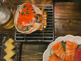 Granchio uovo con miso incolla su Granchio conchiglia con salmone sashimi e birra foto
