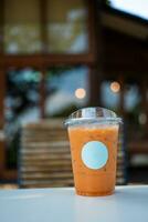 ghiaccio tailandese latte tè nel un' trasparente plastica bicchiere con vuoto bianca logo. foto