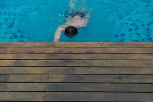 Visualizza a partire dal superiore piscina con uomo nuoto foto