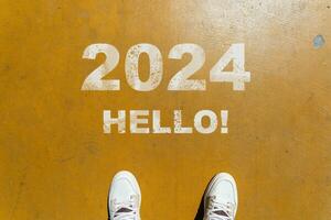il inizio di 2024 è scritto su un' colorato strada. concettuale foto di il In arrivo nuovo anno 2024. nuovo anno concetto, motivazione, attività commerciale promozione, passo inoltrare, in movimento inoltrare, speranza