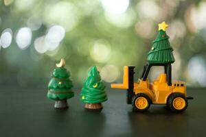 un' giocattolo carrello elevatore a forca autista trasporto Natale alberi a Natale giorno. foto