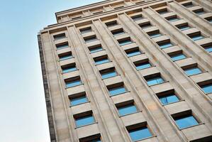 astratto avvicinamento di il rivestito di vetro facciata di un' moderno edificio coperto nel riflessivo piatto bicchiere. architettura astratto sfondo. bicchiere parete e facciata dettaglio. foto