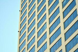 bicchiere edificio con trasparente facciata di il edificio e blu cielo. strutturale bicchiere parete riflettendo blu cielo. astratto moderno architettura frammento. contemporaneo architettonico sfondo. foto