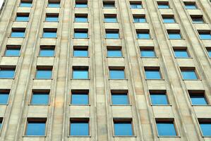 astratto avvicinamento di il rivestito di vetro facciata di un' moderno edificio coperto nel riflessivo piatto bicchiere. architettura astratto sfondo. bicchiere parete e facciata dettaglio. foto