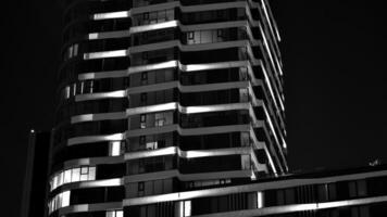 modello di ufficio edifici finestre illuminato a notte. bicchiere architettura ,aziendale edificio a notte - attività commerciale concetto. nero e bianca. foto