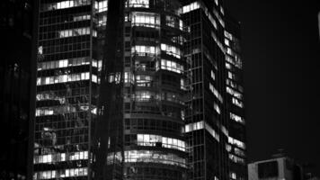 modello di ufficio edifici finestre illuminato a notte. bicchiere architettura ,aziendale edificio a notte - attività commerciale concetto. nero e bianca. foto