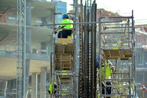 alto salire edificio sotto costruzione. installazione di bicchiere facciata pannelli su un' rinforzata calcestruzzo struttura. foto