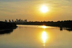 fiume nel il città nel a colorato tramonto nel il sfondo foto