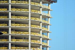 alto salire edificio sotto costruzione. installazione di bicchiere facciata pannelli su un' rinforzata calcestruzzo struttura. foto