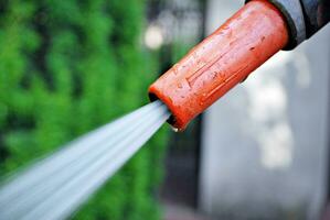 acqua spruzzatura a partire dal un' giardino tubo flessibile foto