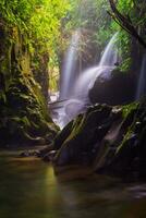 visitare il fascino di Indonesia con il lorong watu cascata, nord bengkulu. un' stretto vicolo foderato con pietra muri, il mattina leggero brilla su il cascata foto