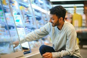 ritratto di indiano uomo acquisto nel un' drogheria negozio. acquisto drogheria per casa nel un' supermercato foto