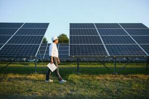 un indiano maschio ingegnere Lavorando su un' campo di solare pannelli. il concetto di rinnovabile energia foto