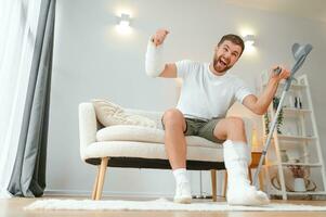 uomo con multiplo fisico arto e corpo lesioni recupera dopo incidente. contento tipo avendo divertimento a casa foto