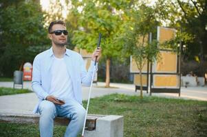 cieco uomo con un' a piedi bastone. foto