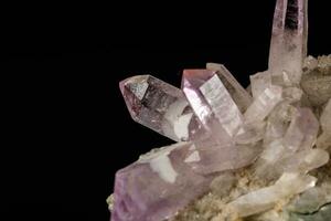 macro minerale pietra ametista cristalli nel roccia su un' nero sfondo foto