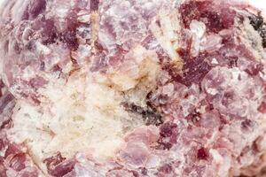 macro minerale pietra lepidolite nel il roccia un' bianca sfondo foto