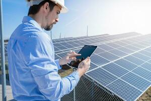 ingegnere Lavorando con un' tavoletta con fotovoltaico solare pannello sistema pianta. foto