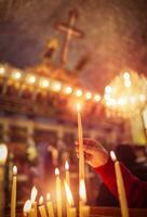 bambino mette un' candela nel il Chiesa foto