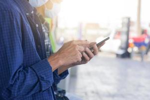 l'uomo indossa la maschera per il viso utilizzando lo smartphone mobile foto