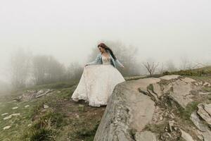 contento bellissimo sposa con lungo capelli Tenere un' vestire. sposo e sposa. nozze foto sessione nel natura. foto sessione nel il foresta di il sposa e sposo.