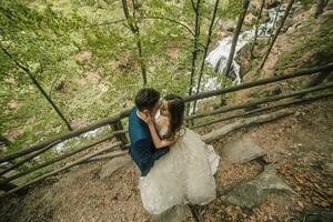 nozze coppia è abbracciare vicino il montagna fiume. sposo e sposa . natura nozze servizio fotografico. foto sessione nel il foresta di il sposa e sposo.