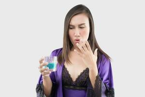 un' donna nel viola camicia da notte sentire bruciare nel sua bocca perché utilizzando collutorio foto