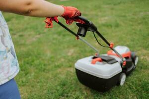 prato motore su verde erba nel moderno giardino. macchina per taglio prati. sicurezza attrezzatura con giardino utensili foto