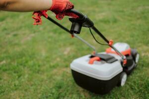 prato motore su verde erba nel moderno giardino. macchina per taglio prati. sicurezza attrezzatura con giardino utensili foto