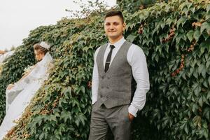 sposa e sposo nel il giardino tra verde. reale nozze concetto. elegante della sposa vestito con un' lungo treno. tenerezza e calma. ritratto fotografia foto