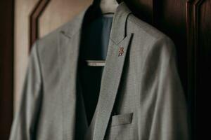 un' grigio elegante giacca si blocca su un' Marrone sfondo. Uomini stile. Abiti. moda e attività commerciale. dettagli foto