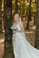 il sposa è a piedi contro il sfondo di un' fiaba nebbia nel il foresta. il raggi di il sole rompere attraverso il Fumo, un' fiaba nozze foto