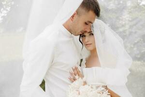 bellissimo nozze coppia. il sposo baci il sposa su il fronte. contento nozze fotografia di sposa e sposo a nozze cerimonia. foto