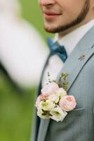 ritagliata foto. quello dello sposo blu arco legare, barba e fiore all'occhiello. elegante sposo su il sfondo di un' verde campo. bianca camicia. moda e stile. foto