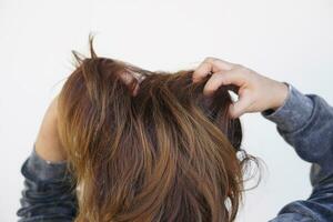 donna uso mani per graffiare sua ghiacciato capelli su testa, isolato su bianca sfondo. concetto, capelli Salute i problemi. forfora, fungo su cuoio capelluto, allergico per shampoo o pidocchio. foto