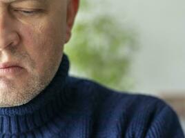 ritratto di il medio anziano uomo con grigio capelli, indossare caldo, buio blu maglione. persone foto