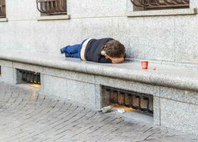 ubriaco persona dorme su il strada. concetto foto