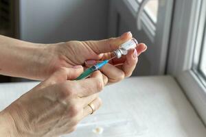 vicino risultato di il donna preparazione medicina per iniezione. assistenza sanitaria foto