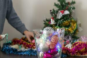 vicino su tiro di nuovo anno decorazioni. poco ragazzo decorazione Natale albero. nuovo anno mutevole numeri. vacanza foto