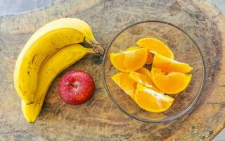 banane affettato arance e rosso Mela frutta su di legno tavolo. foto