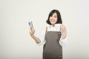 asiatico sorridente femmina imprenditore o barista indossare un grembiule al di sopra di bianca sfondo, concetto piccolo attività commerciale foto